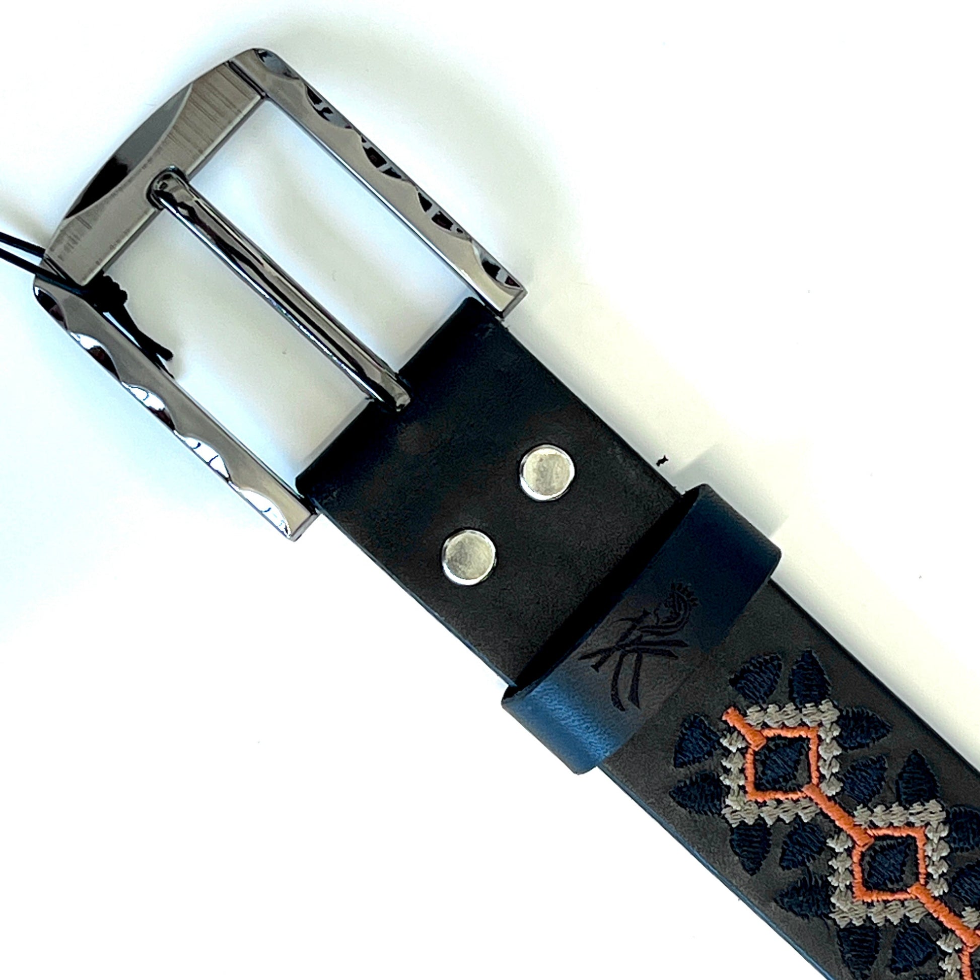 dettaglio della fibbia della cintura ricamata con motivo geometrico in colore nero e arancione