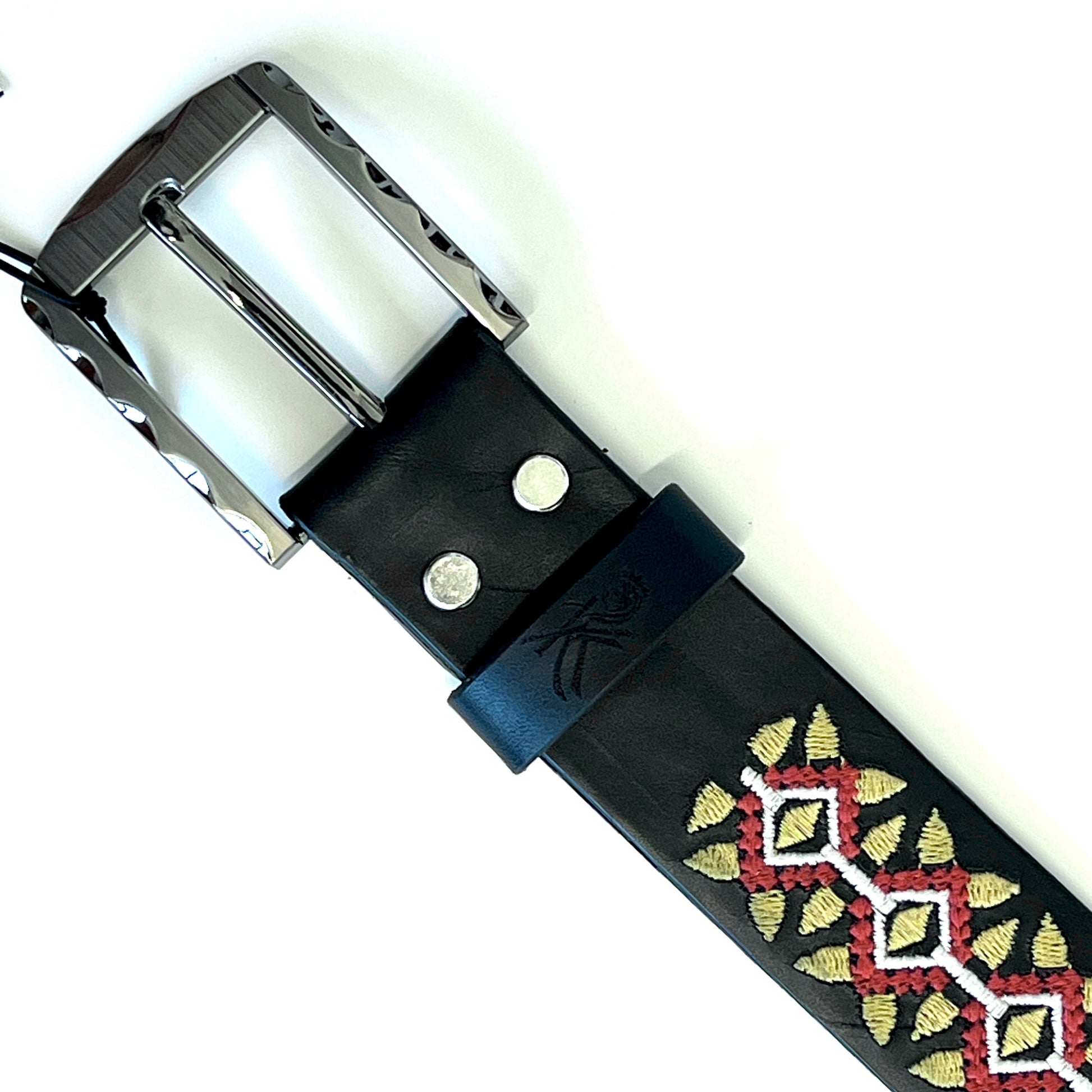 dettaglio fibbia della cintura artigianale in pelle ricamata con motivo geometrico giallo e rosso